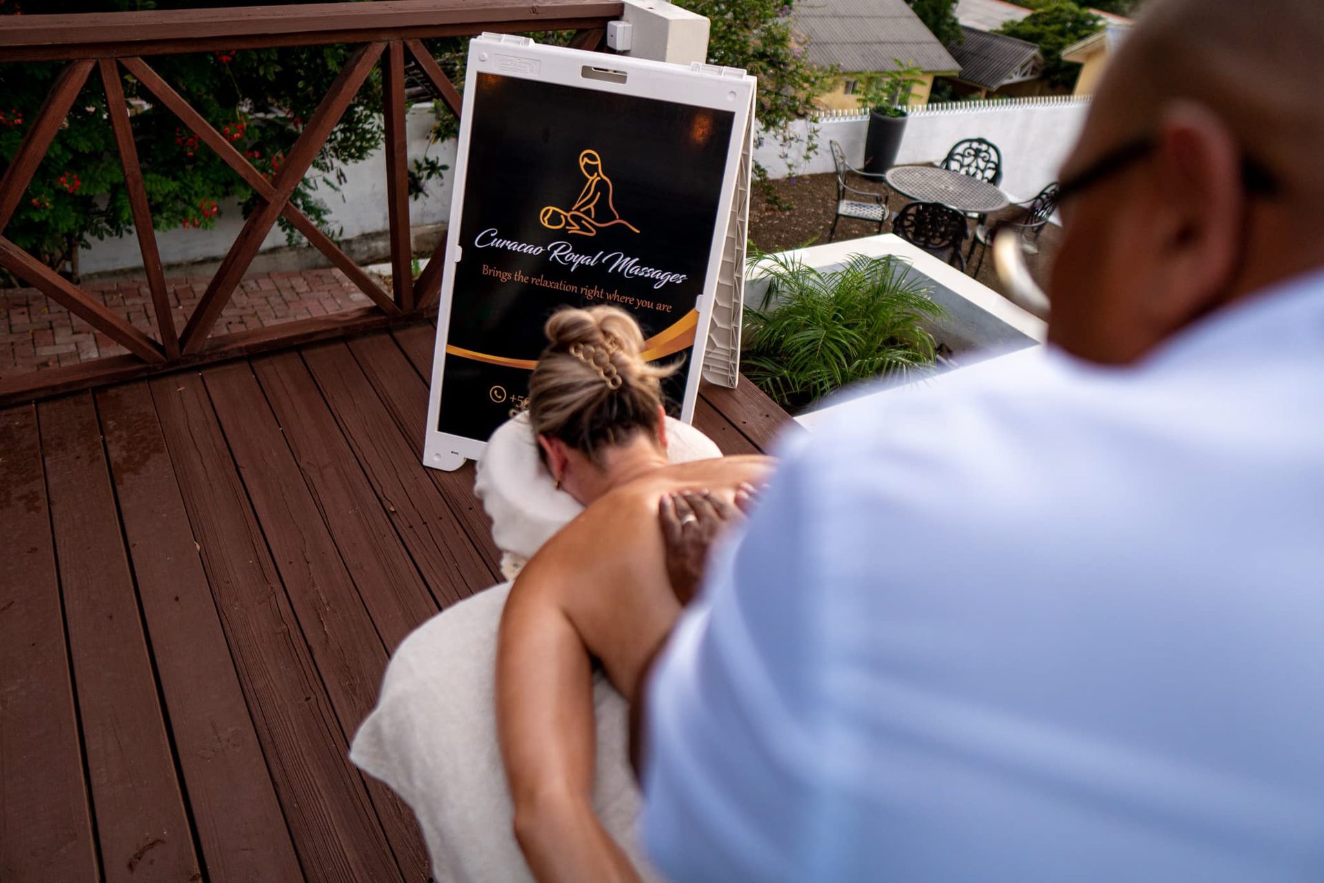 A shoulder massage on the terrace beside the sign of Curacao Royal Massages