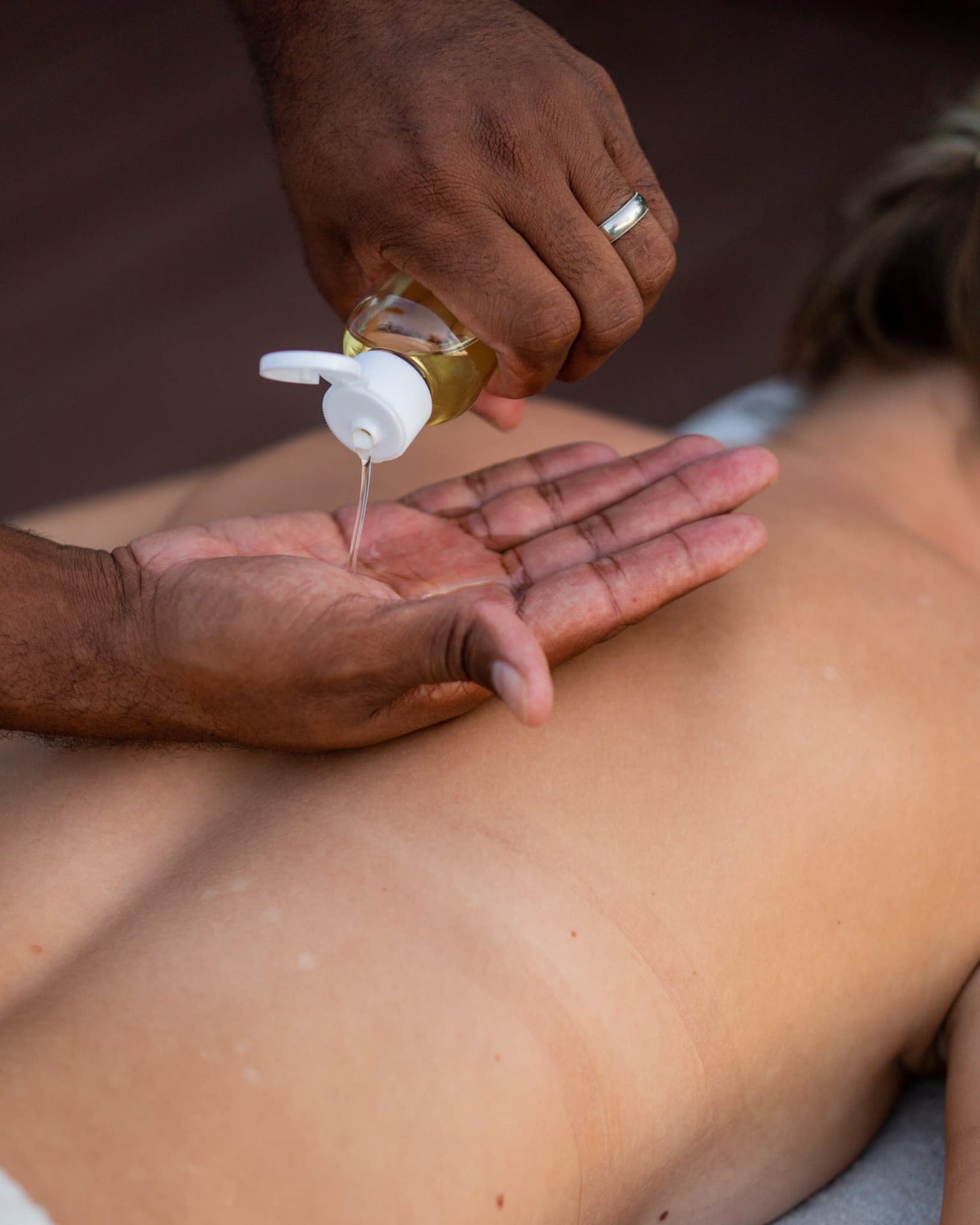 Massage oil poured onto a back