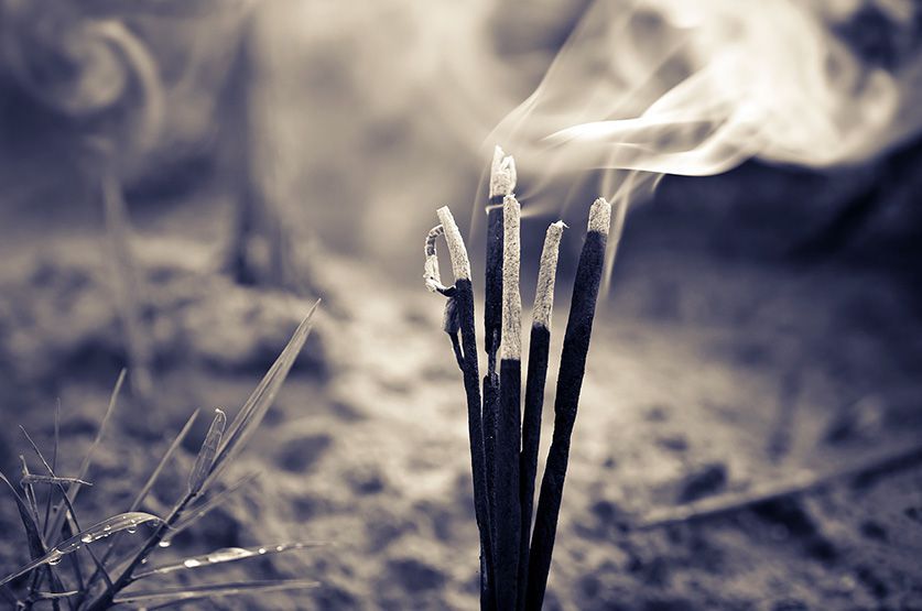Incense sticks burning in the sand