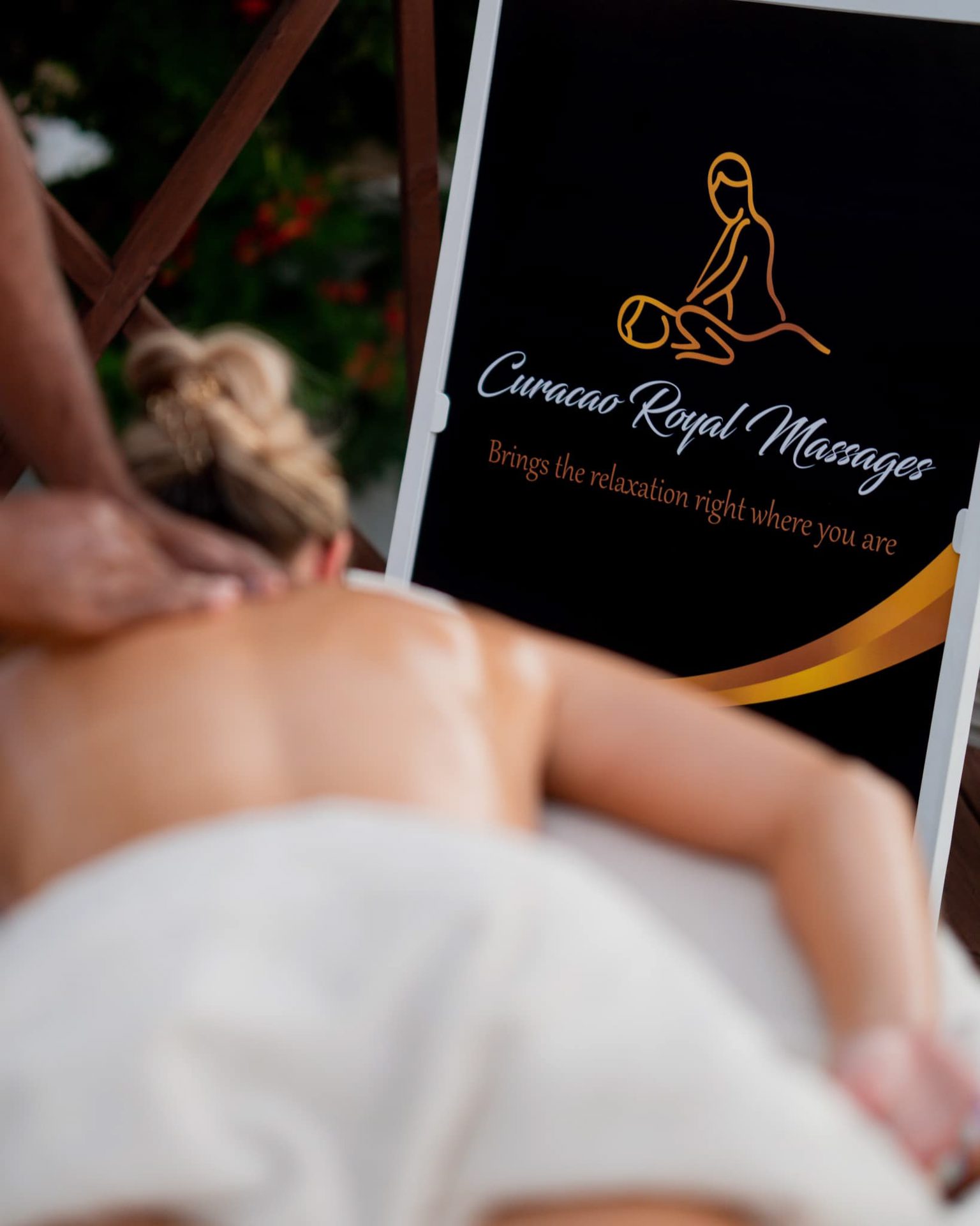 A shoulder massage beside the logo of Curacao Royal Massages